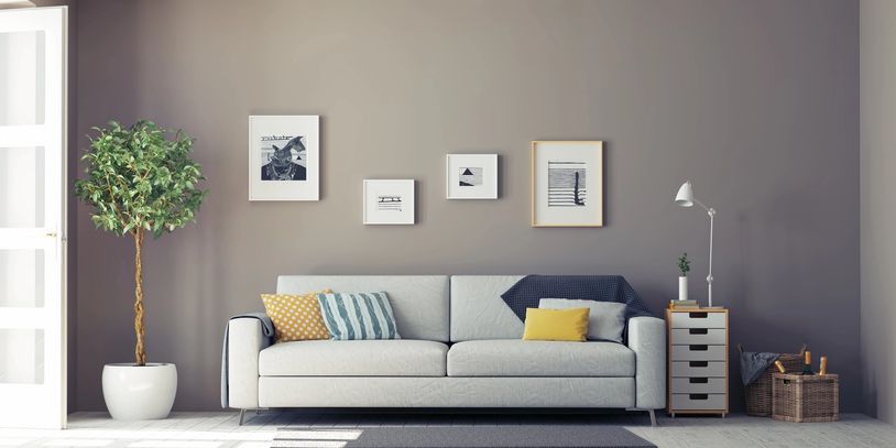 Modern living room with a light gray sofa and framed artwork.