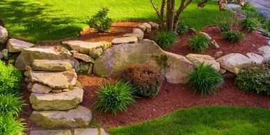 Landscape rocks and boulders with mulch and new plant installation