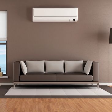 Modern living room with brown sofa and wall-mounted air conditioner.