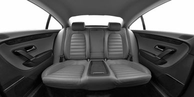 Backseat of a modern car with gray leather seats.