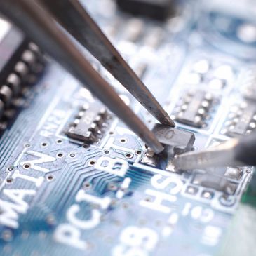 A technician micro-soldering components onto a logic board