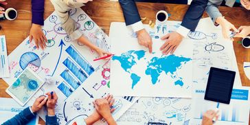 Team analyzing global market data and statistics in a collaborative meeting.