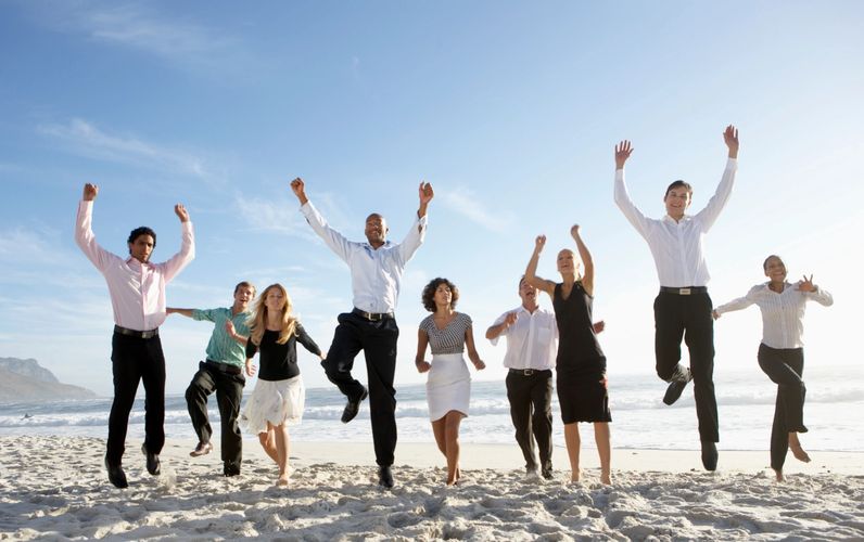 business people on the beach happily jumping in sand