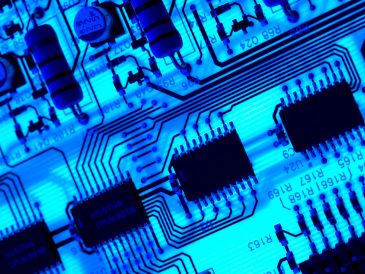 Close-up of a blue circuit board with integrated circuits.