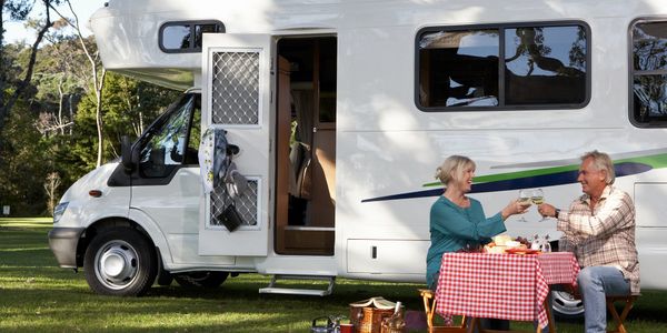 couple eating next to a caravan