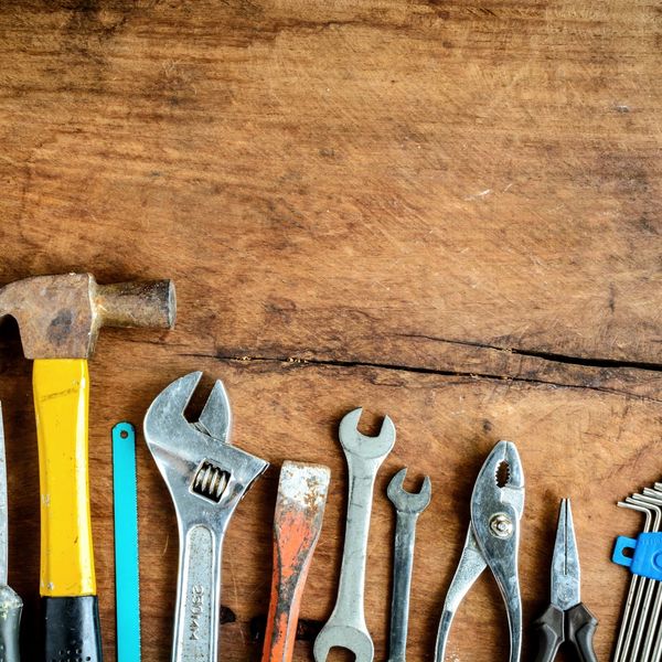 A selection of tools laid on a wooden worktop.