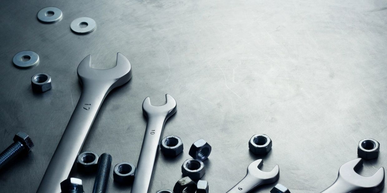 Wrenches and nuts on a metal surface.