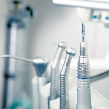 Dental equipment: triplex air/water syringe and dental handpieces, inside a dentist office. 