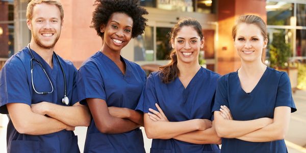 Four people wearing blue scrubs