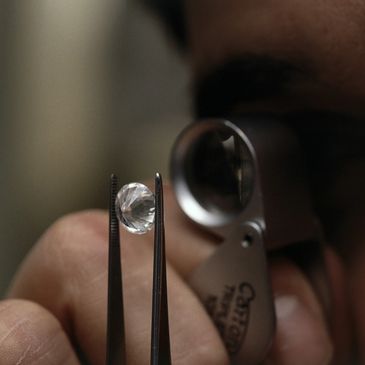 A man looking at a diamond with microscope