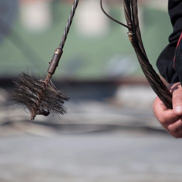 a man ready to sweep a chimney.