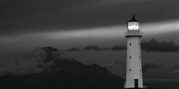Black and white image of a lighthouse at night.