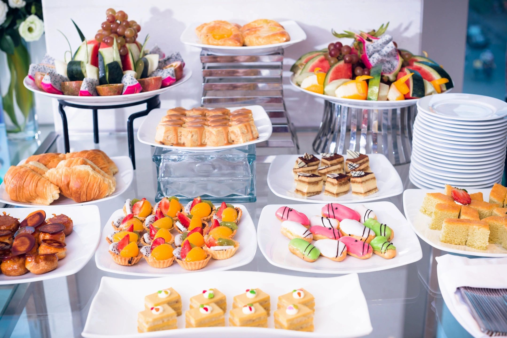 Elegant dessert and fruit buffet with pastries and colorful treats.