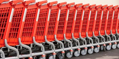 Row of red shopping carts neatly lined up outdoors.