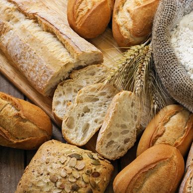 Various freshly baked breads with wheat and flour sack.
