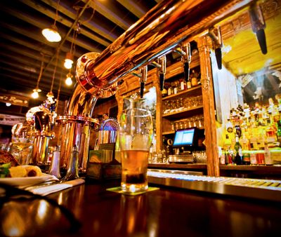 Beer being poured from the tap at a bar with a Point of Sale terminal active in the background