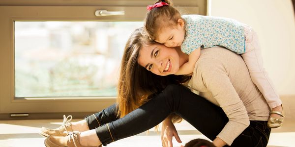 Babysitter playing with a child in a home.