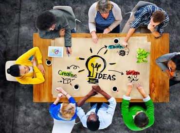 Group brainstorming creative ideas around a table.