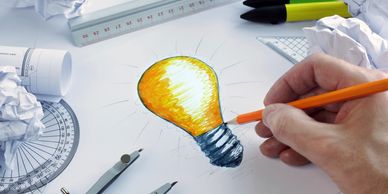 Idea bulb drawn with a hand and pencil to illustrate product management planning