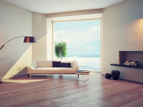 Minimalist living room with a large window overlooking the ocean.