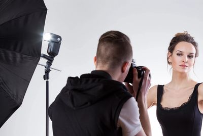 Photographer capturing a woman's photo in a studio.