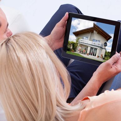 Couple viewing house listing on a tablet together.