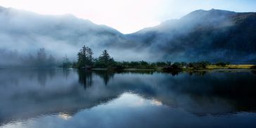 Soothing photograph of a lake surrounded by mountains 