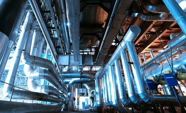 A complex network of large metallic pipes in an industrial setting.