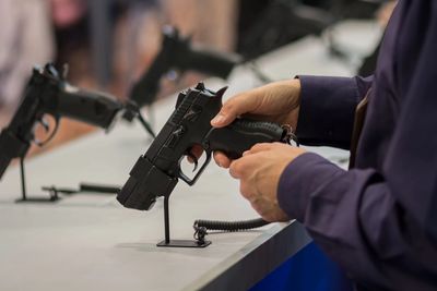 Person selecting a semi automatic pistol from a display