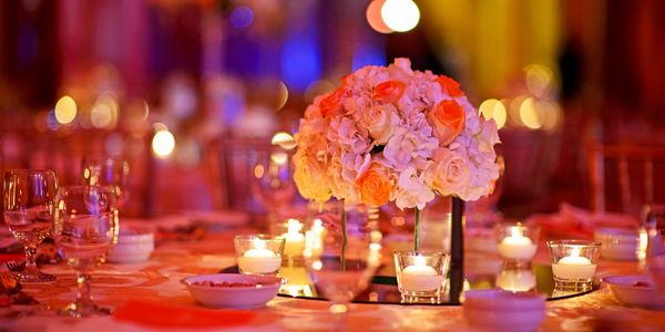 Elegant floral centerpiece with glowing candles on a beautifully set table.