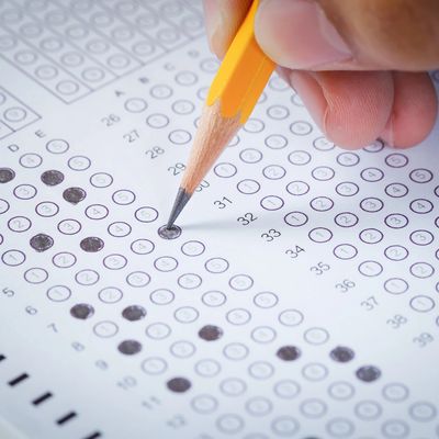 Student fills in bubbles on a test answer sheet for GED