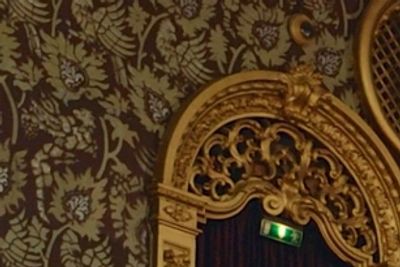Ornate golden architectural detail with a green exit sign.