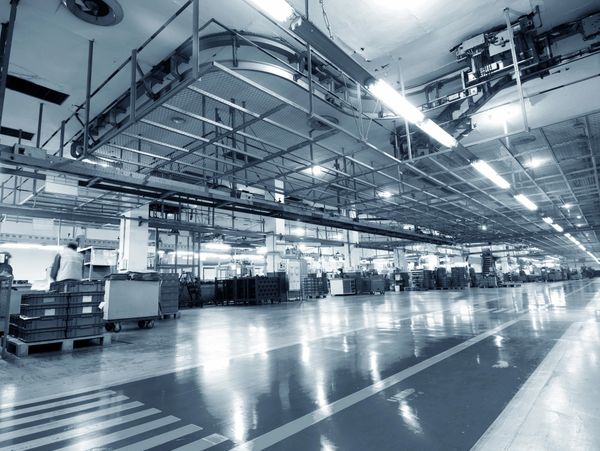 Spacious, well-lit industrial factory floor with machinery and workers.