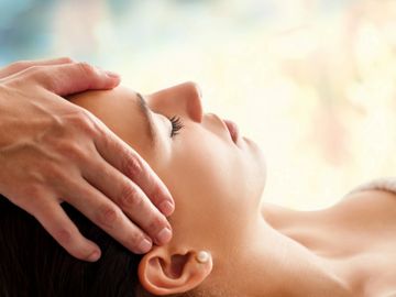 Practitioner working on temples of woman patient.