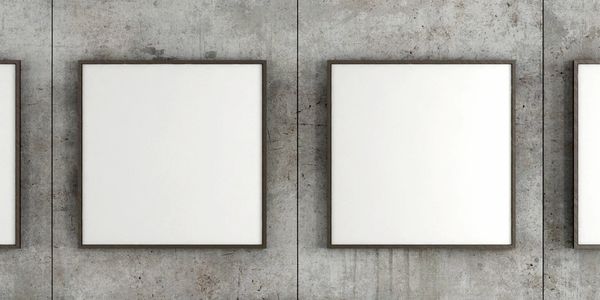 Two blank square frames on a concrete wall.