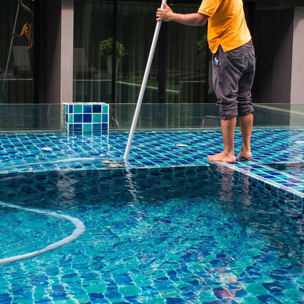 Man vacuuming out a swimming pool