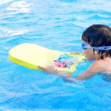 Child swimming with float and goggles