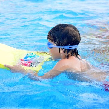 Child swimming with float and goggles