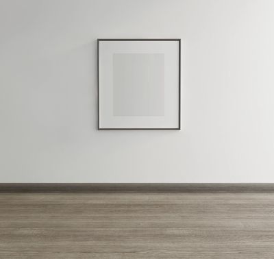 Minimalist empty room with a framed square artwork on the wall.