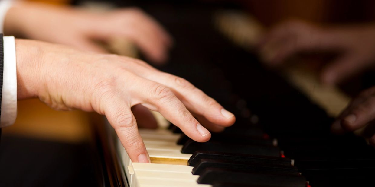 Hands playing a piano