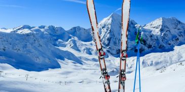 Skis and poles standing in snowy mountain landscape.