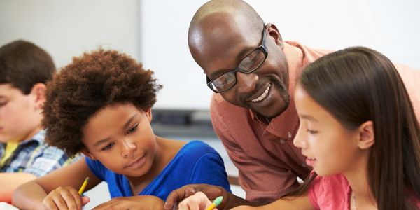 Teacher helping students in classroom.