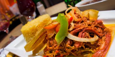 Plate with shredded meat, rice, plantain, and vegetables.