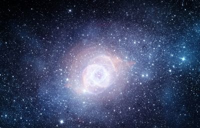A glowing nebula surrounded by countless stars in deep space.