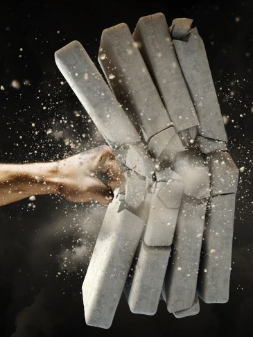 Fist breaking a stack of concrete bricks.