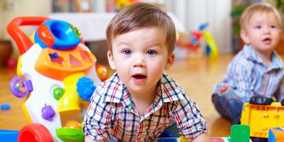 Two toddlers playing with toys indoors.