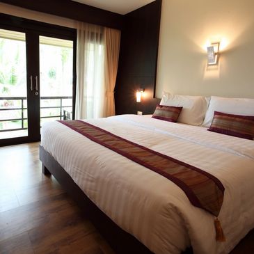 Modern bedroom with large bed and balcony access.