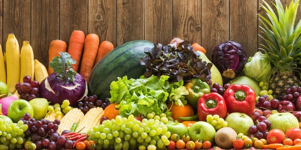 A vibrant display of fresh fruits & vegetables, including pineapples, bananas, grapes & peppers 