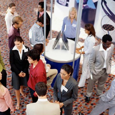 Professionals networking at a business event in a conference setting.