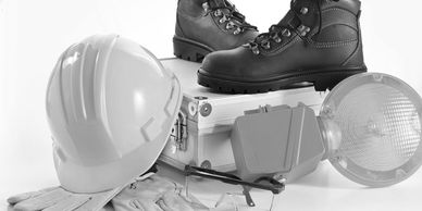 Safety gear including helmet, gloves, boots, and light for construction or industrial work.